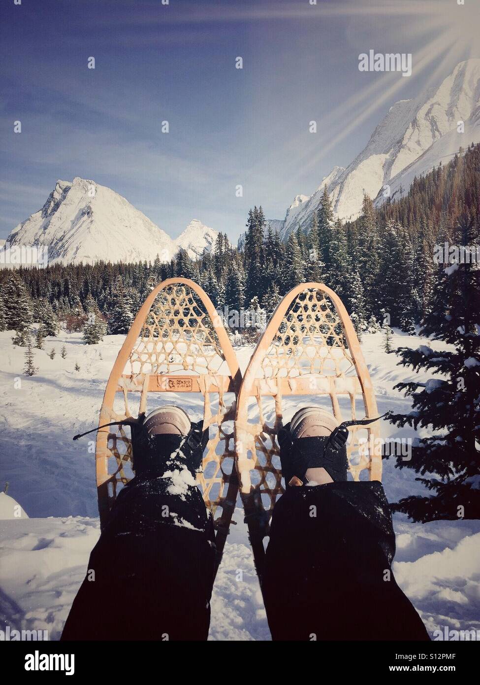Resting while snowshoeing in the Rocky Mountains. Stock Photo