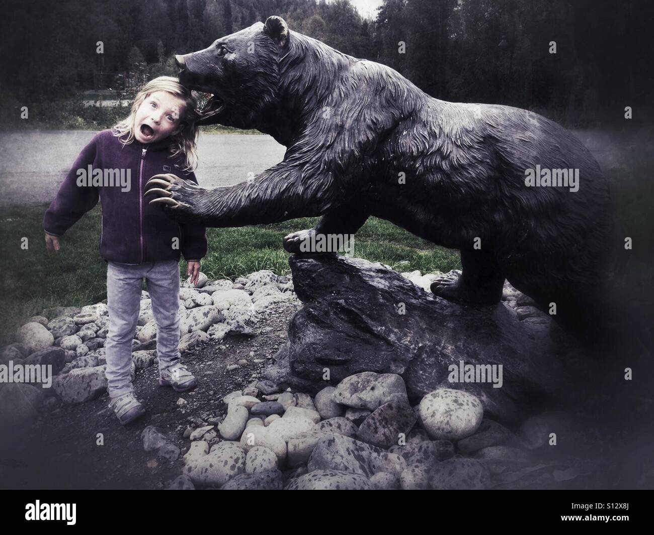 A surprised girl is 'bitten' by a grizzly bear. - Smartphone Captured Stock Image