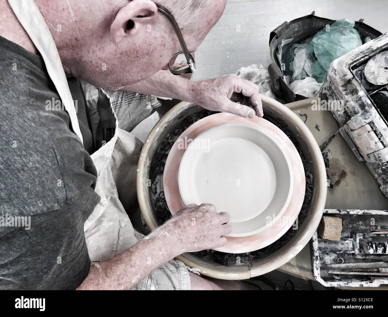 Potter on the wheel make pie plate Stock Photo
