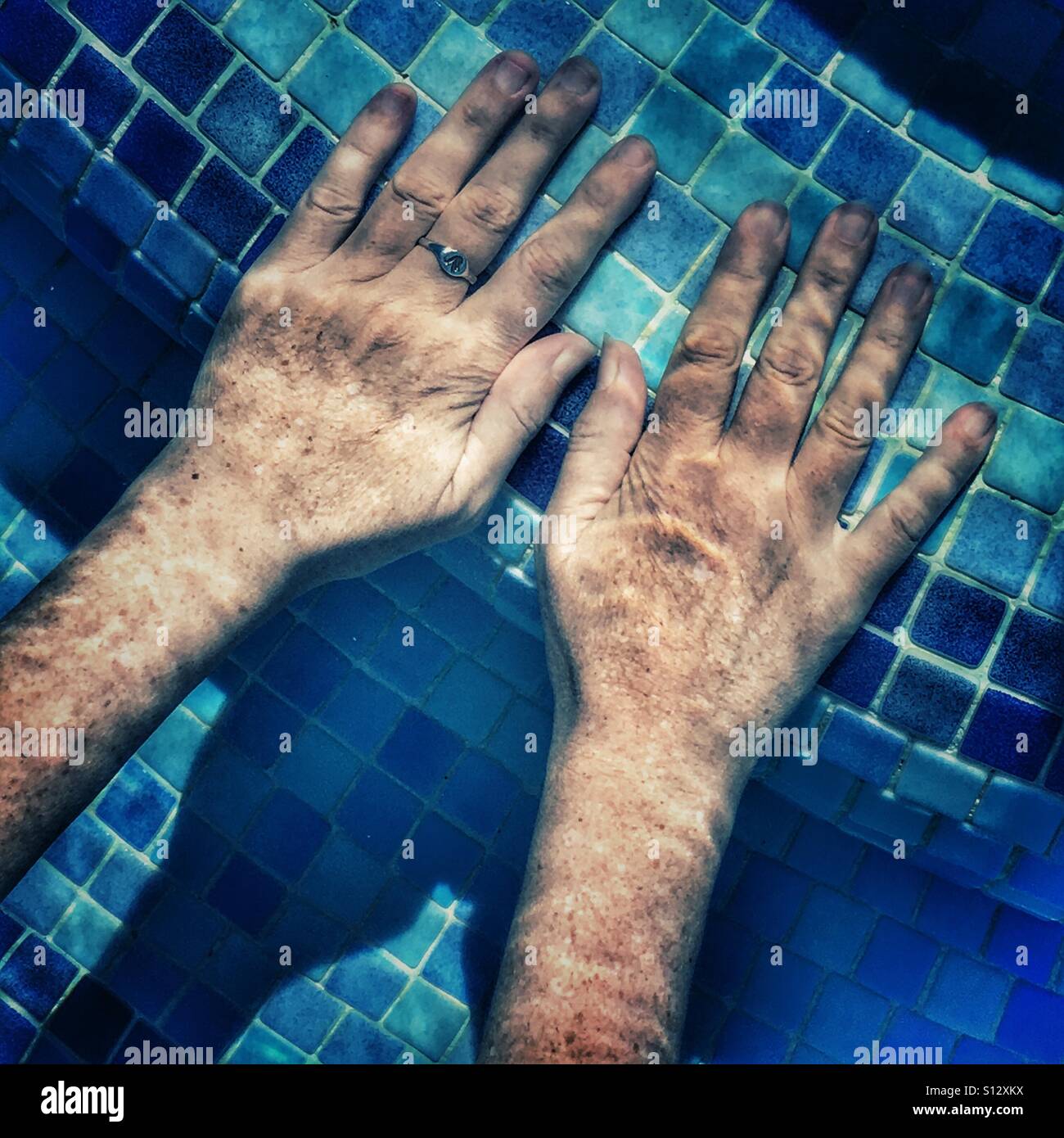 Hands in swimming pool - Smartphone Captured Stock Image