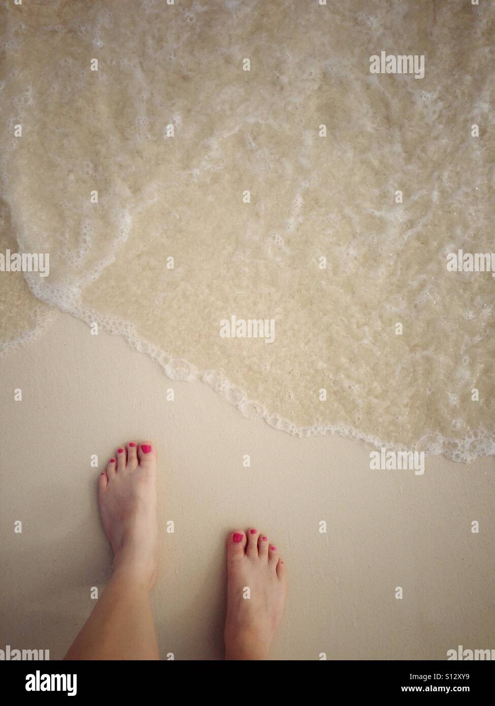 Painted toenails on feet ready to feel the surf. - Smartphone Captured Stock Image