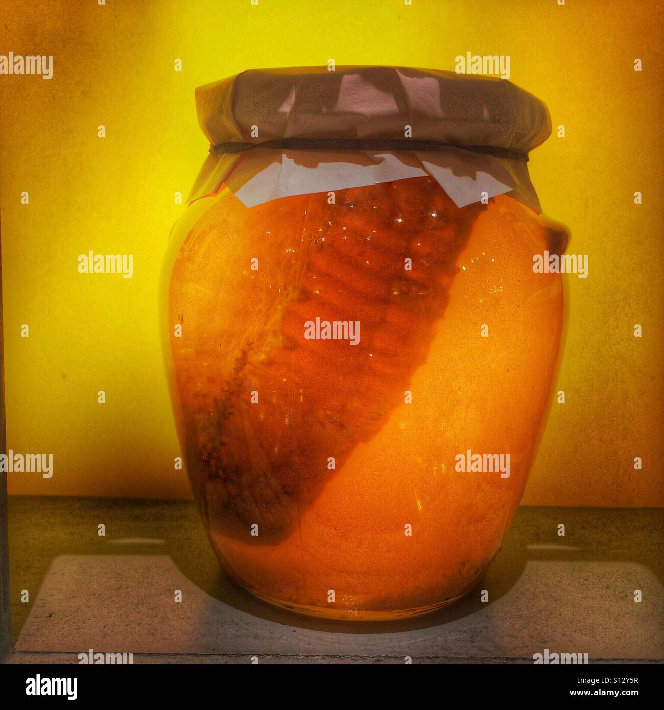 Jar of honey with honeycomb inside. - Smartphone Captured Stock Image