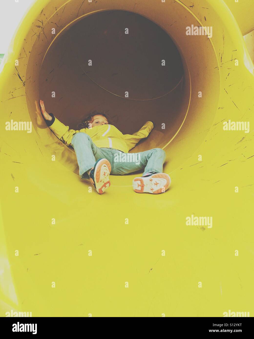 Boy coming down slide Stock Photo
