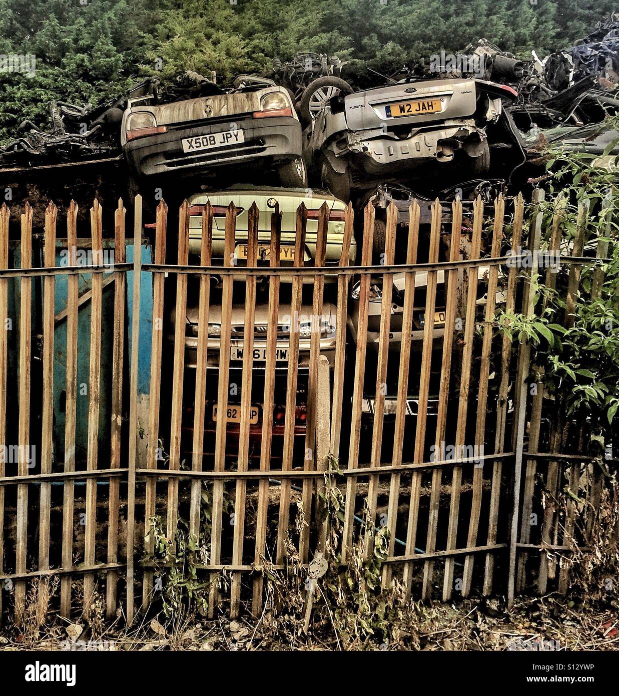 Scrapped cars behind a metal  fence - Smartphone Captured Stock Image