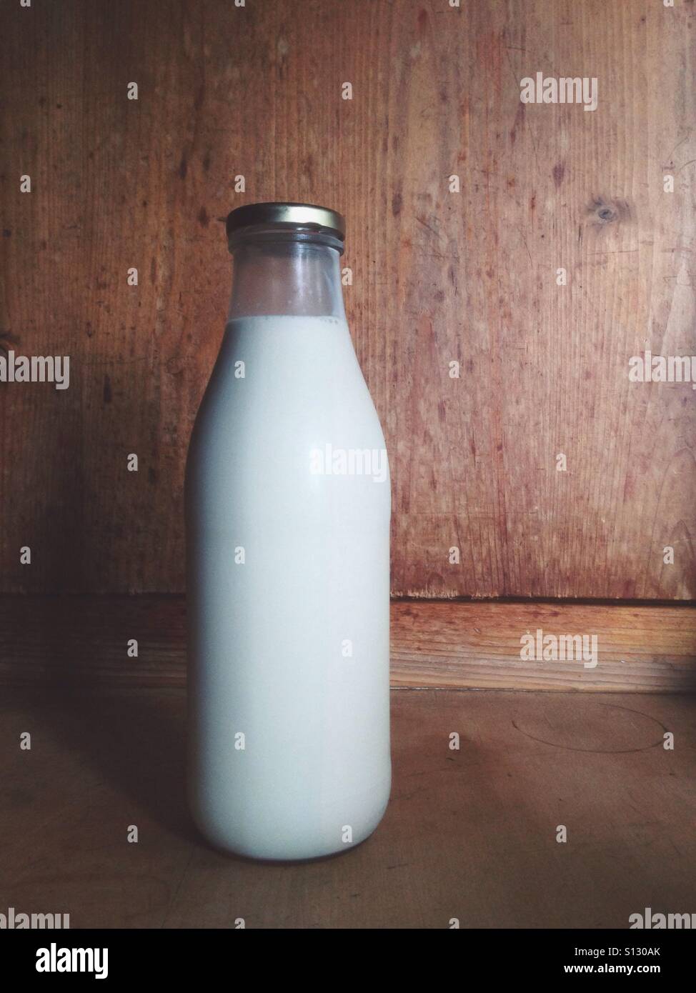 A litre bottle of milk on a kitchen worktop with the soft glow of the morning sunlight Shining in Stock Photo