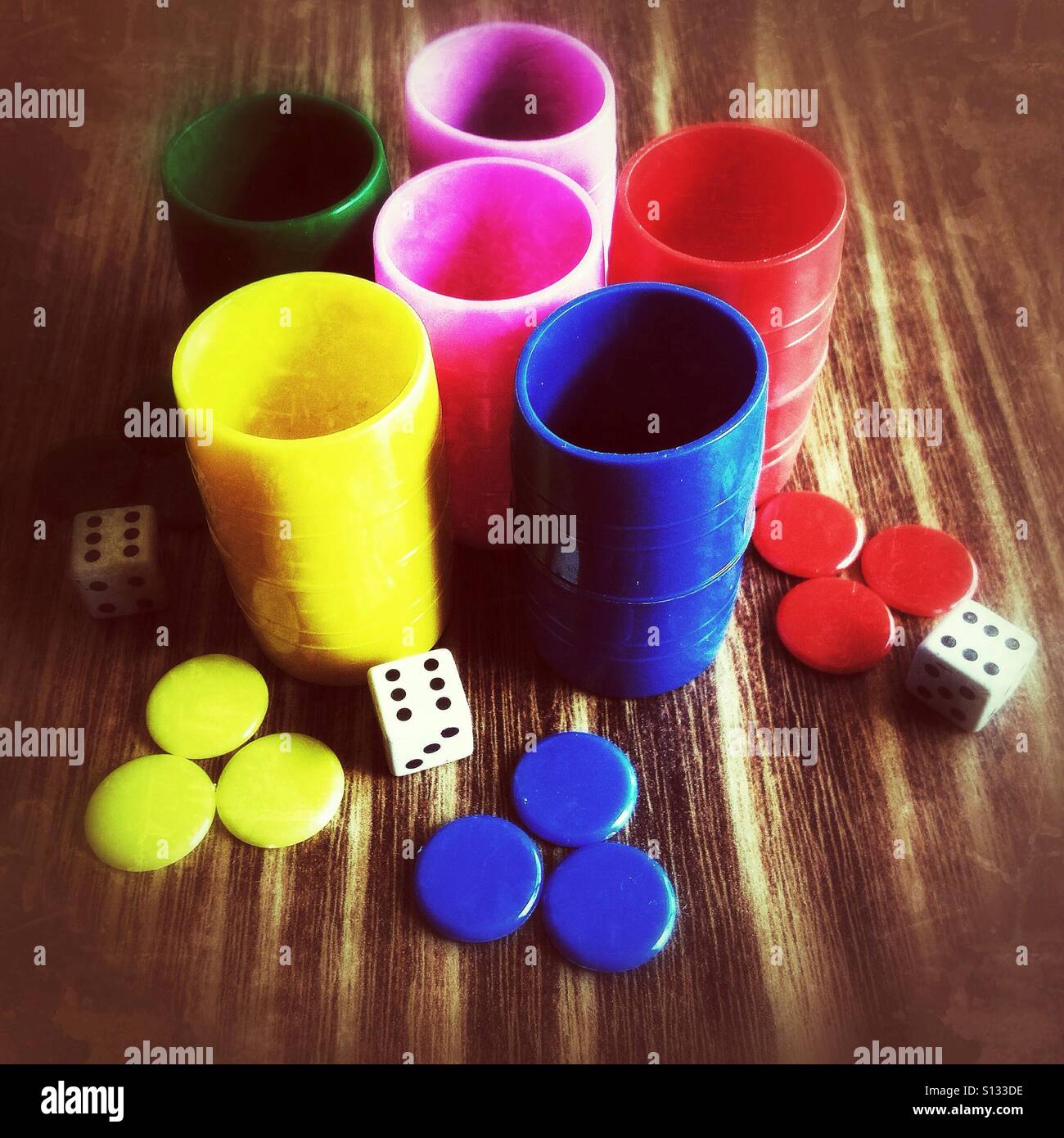 Dices, pieces and cups on a wooden table - Smartphone Captured Stock Image