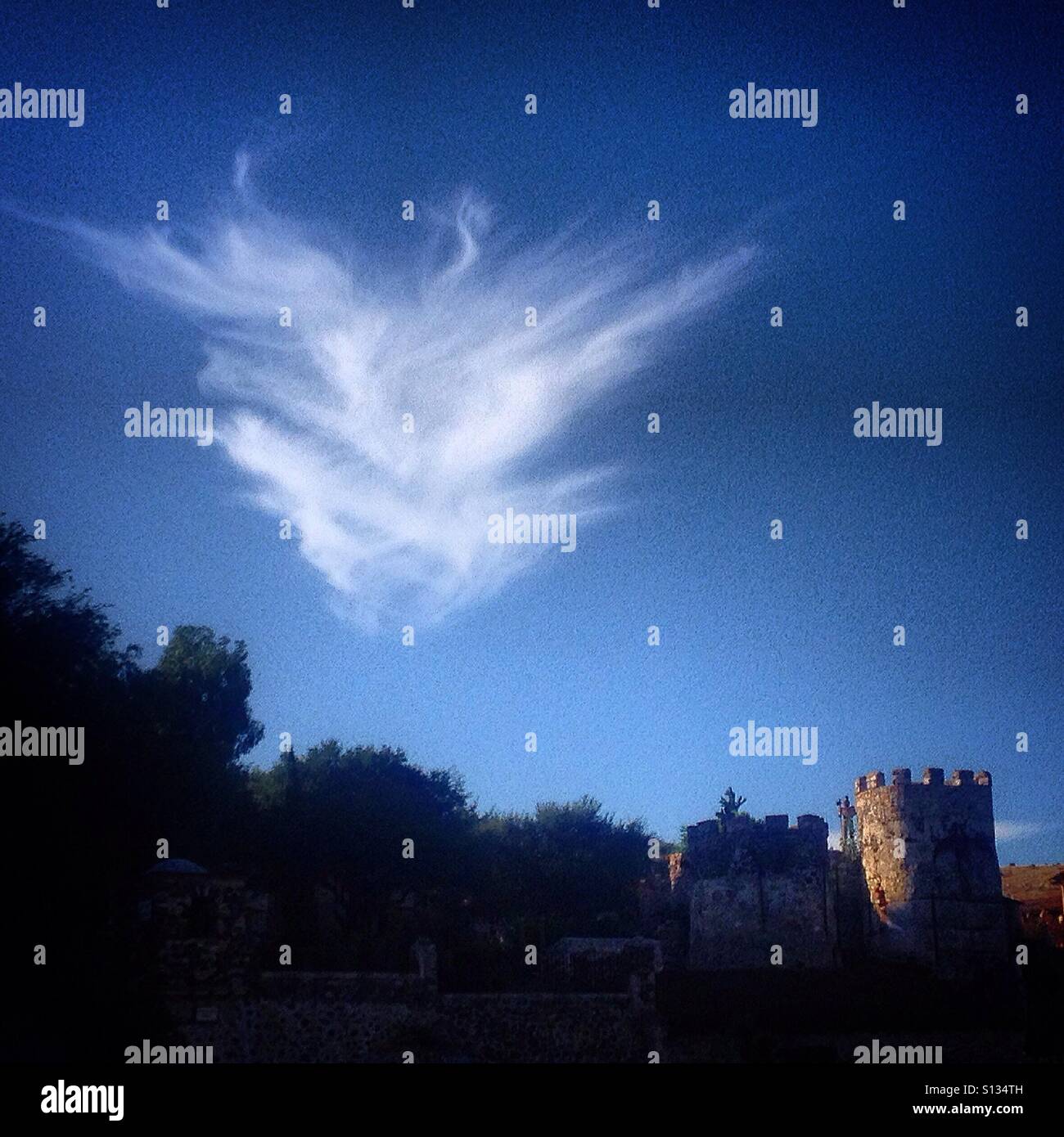 A cloud over a castle shaped building from Hostal Medieval in Peña de Bernal, Queretaro, Mexico - Smartphone Captured Stock Image