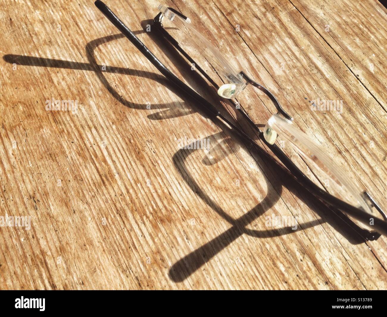 Glasses on a wooden surface with a shadow Stock Photo - Alamy
