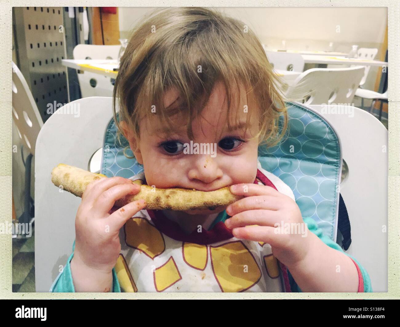 Toddler eating pizza Stock Photo