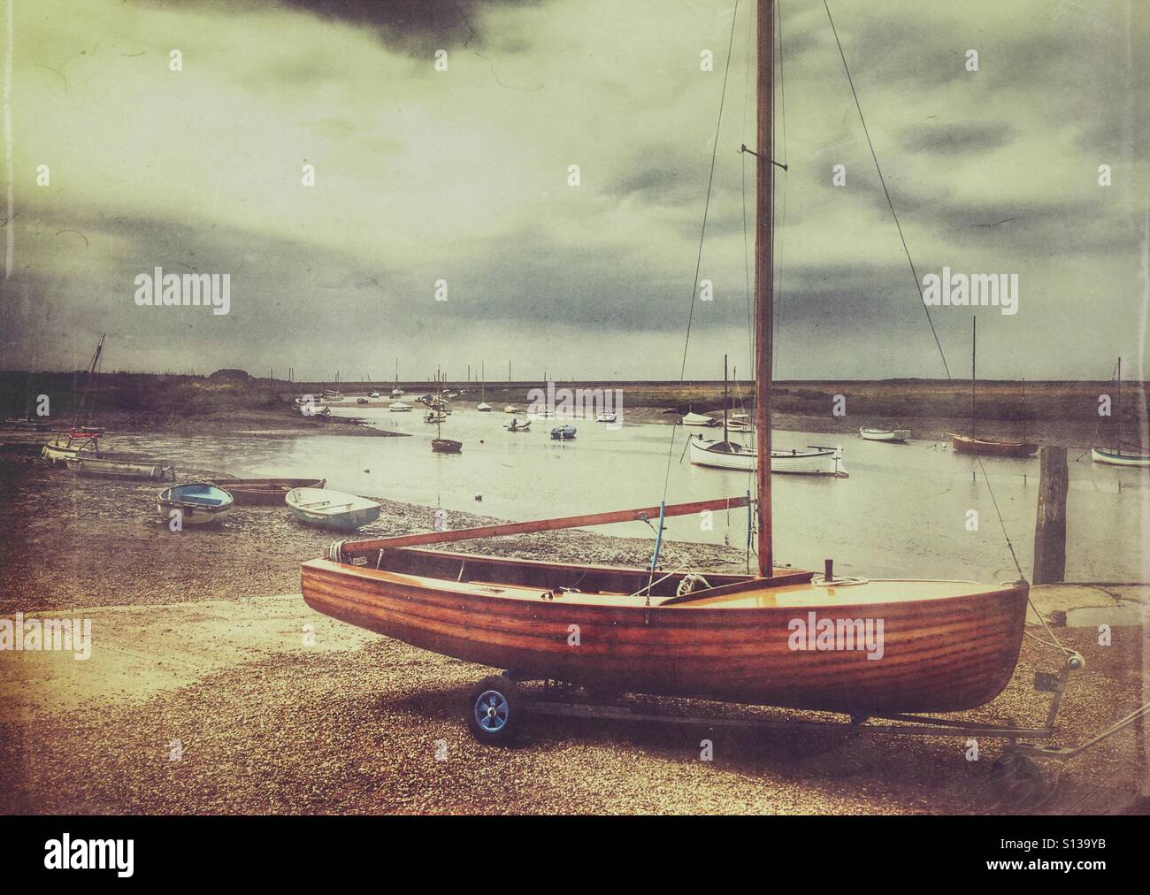 Wooden sail boat on a trailer. Burnham Overy Staithe, Norfolk, England, UK. - Smartphone Captured Stock Image