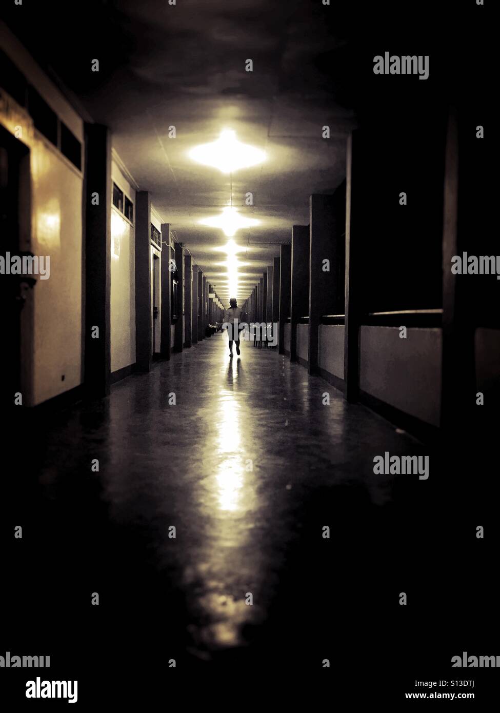 Woman walks in a school hallway at night Stock Photo Alamy