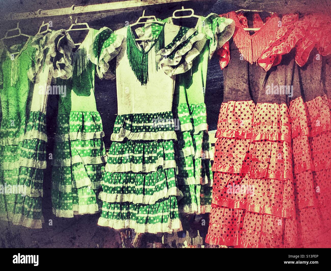 Traditional Spanish flamenco dresses displayed on a market stall - Smartphone Captured Stock Image