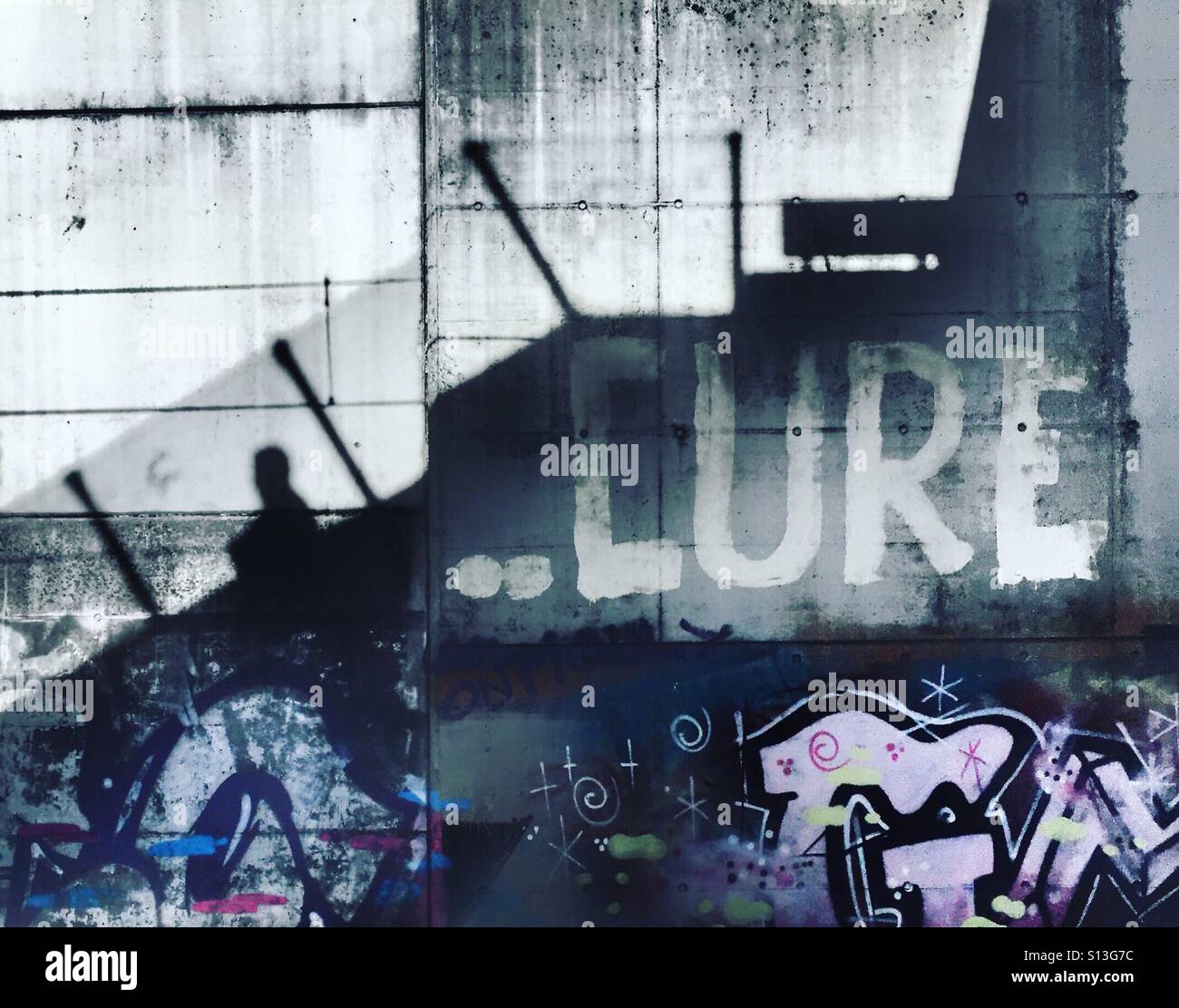 Shadow of man walking past graffiti reading CURE - Smartphone Captured Stock Image