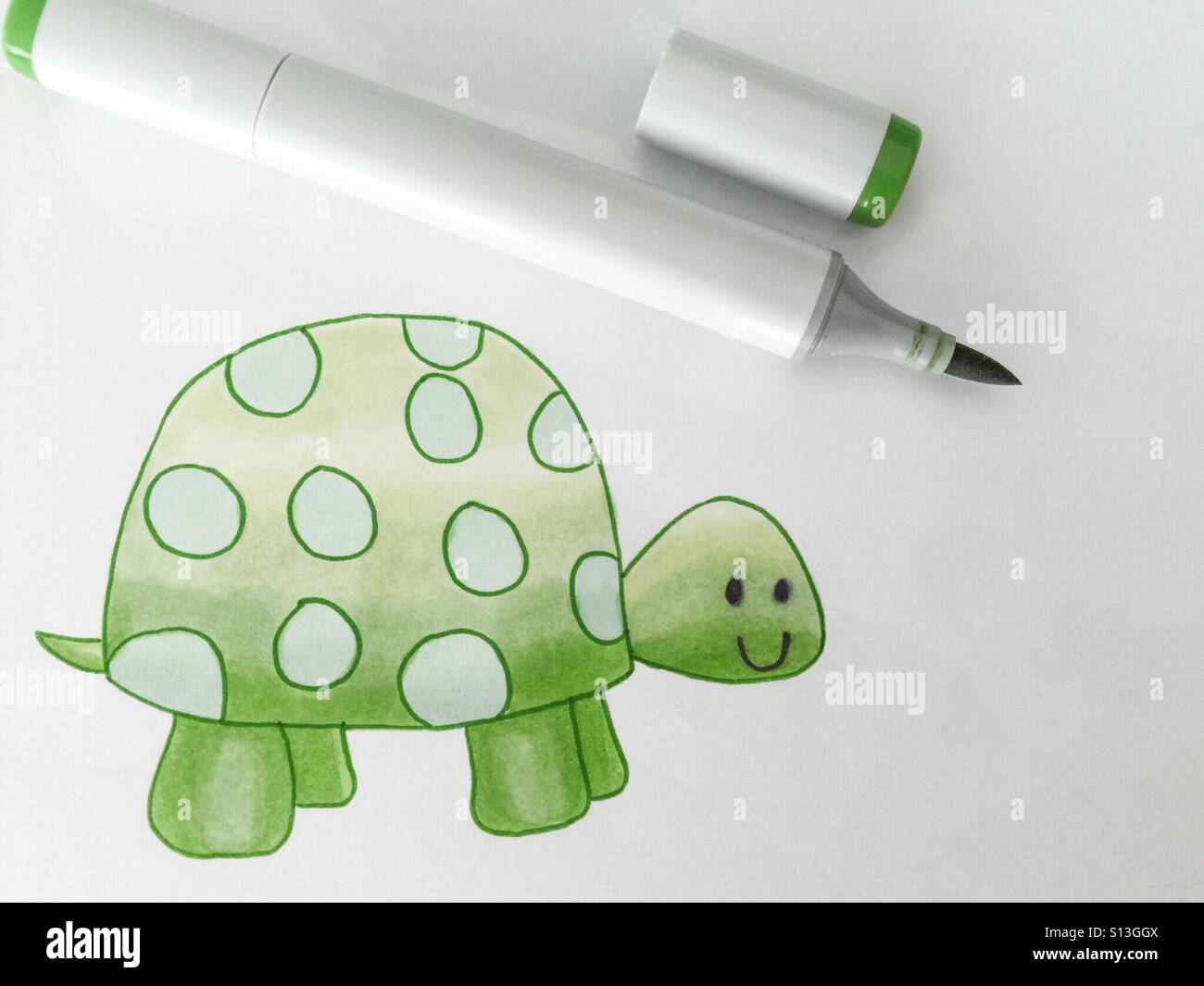 A marker lies beside a child's drawing of a turtle. - Smartphone Captured Stock Image