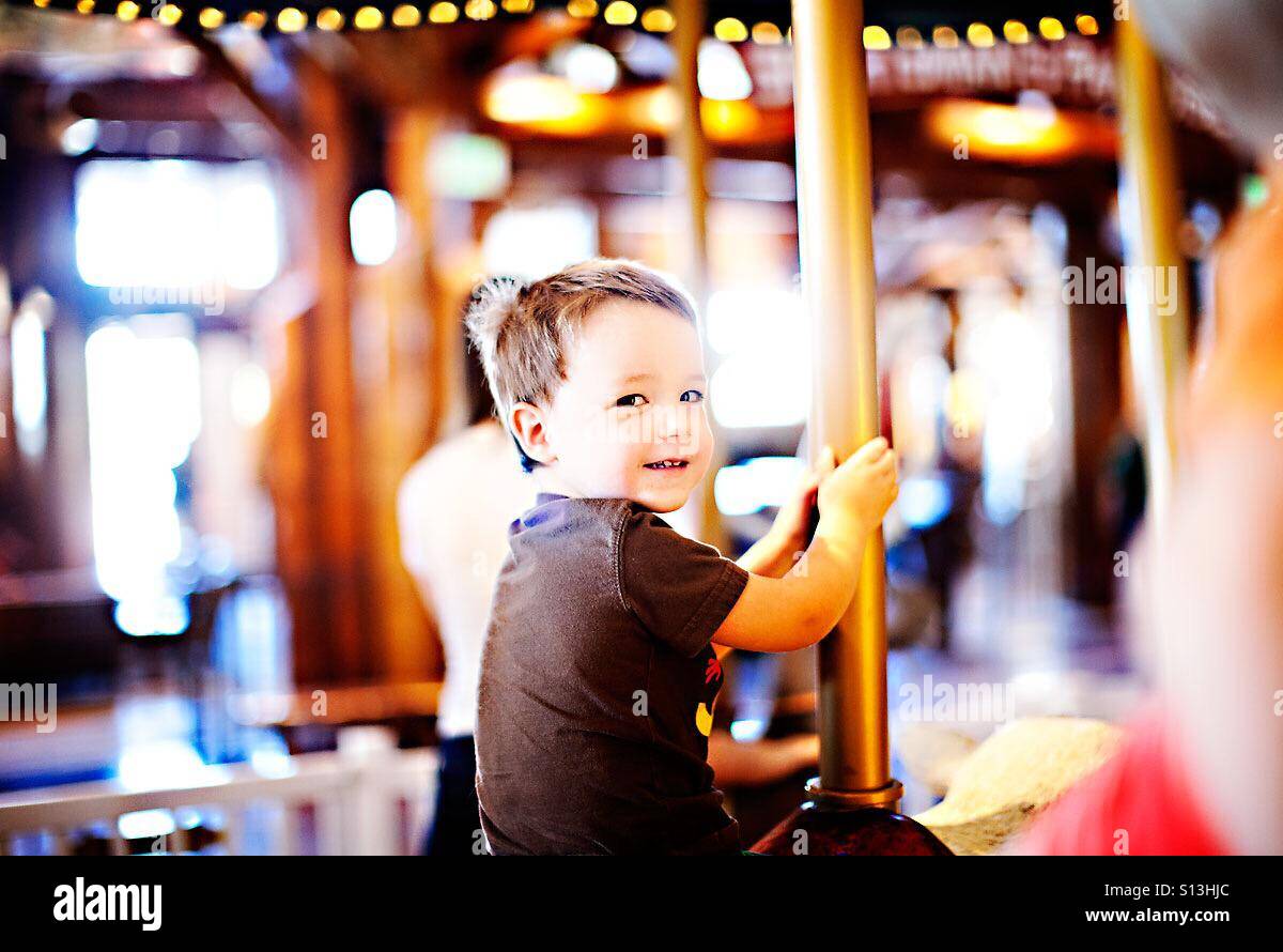 Boy on merry go round carousel Stock Photo