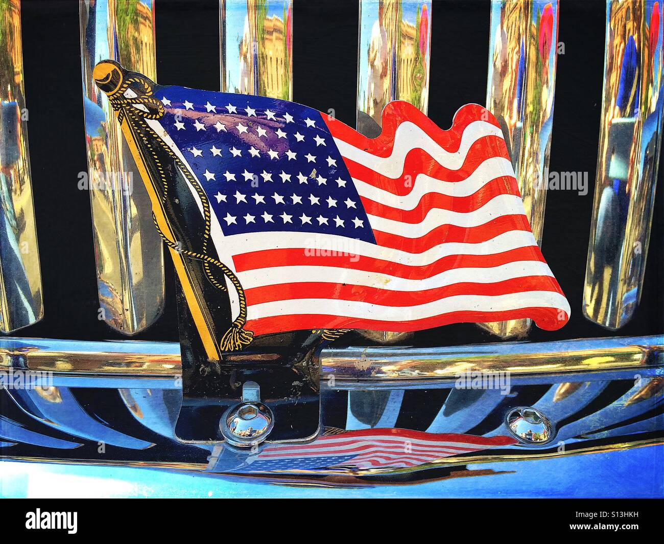 Flag of the United States on front of classic car with reflections in the chrome grill and bumper. Taken at classic car show in Bozeman, Montana, USA - Smartphone Captured Stock Image