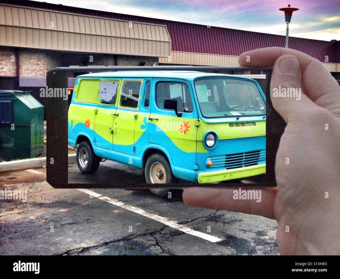 Taking a photograph with my mobile device of a colorfully painted van. Stock Photo