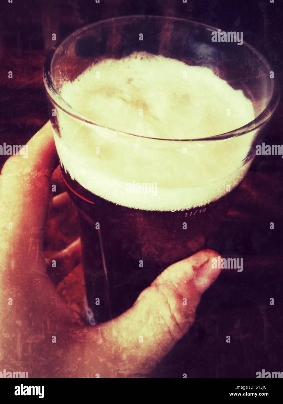 A hand holding a pint of lager. - Smartphone Captured Stock Image