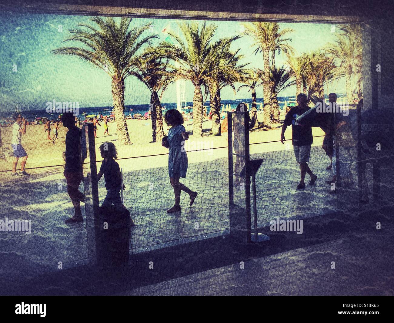 People walking past the Ale-Hop store on the Arenal beach promenade in summer. Javea, Alicante, Spain - Smartphone Captured Stock Image