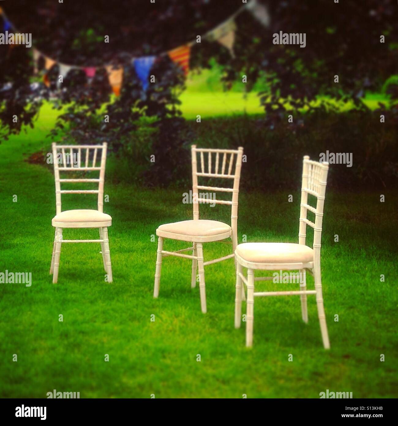 Three dining chairs outside after a party. Mobile phone photo with some phone or tablet post processing. - Smartphone Captured Stock Image