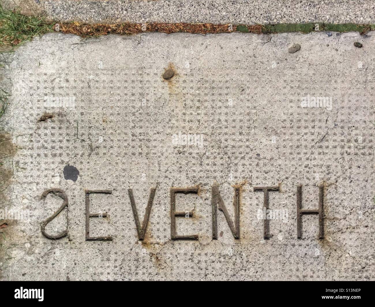 An error in the stamp in a concrete sidewalk. - Smartphone Captured Stock Image