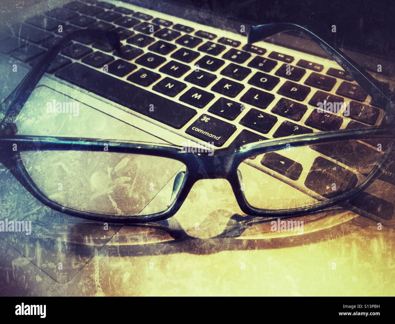 Reading glasses on laptop keyboard - Smartphone Captured Stock Image