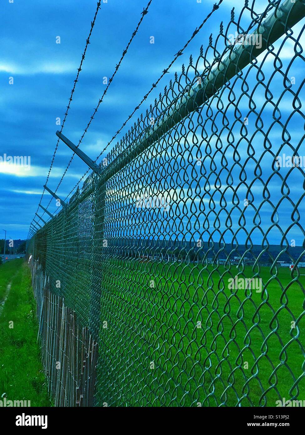 Security fence - snow fence, chain link fence, and barbed wire - Smartphone Captured Stock Image