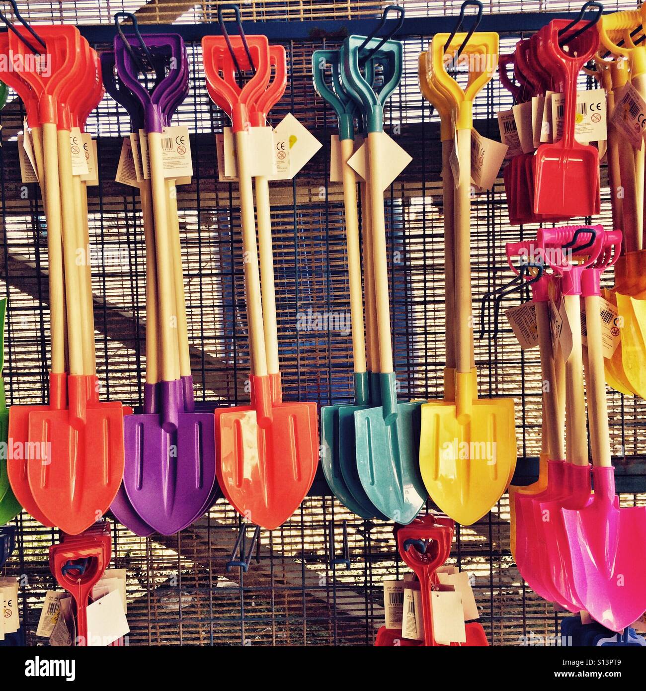 Colourful beach spades on a sale at a seafront shop England UK Stock Photo