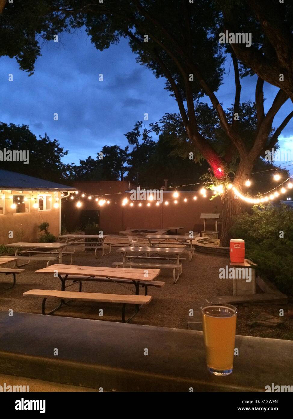 Evening lights and a beer over an outside patio space. Stock Photo