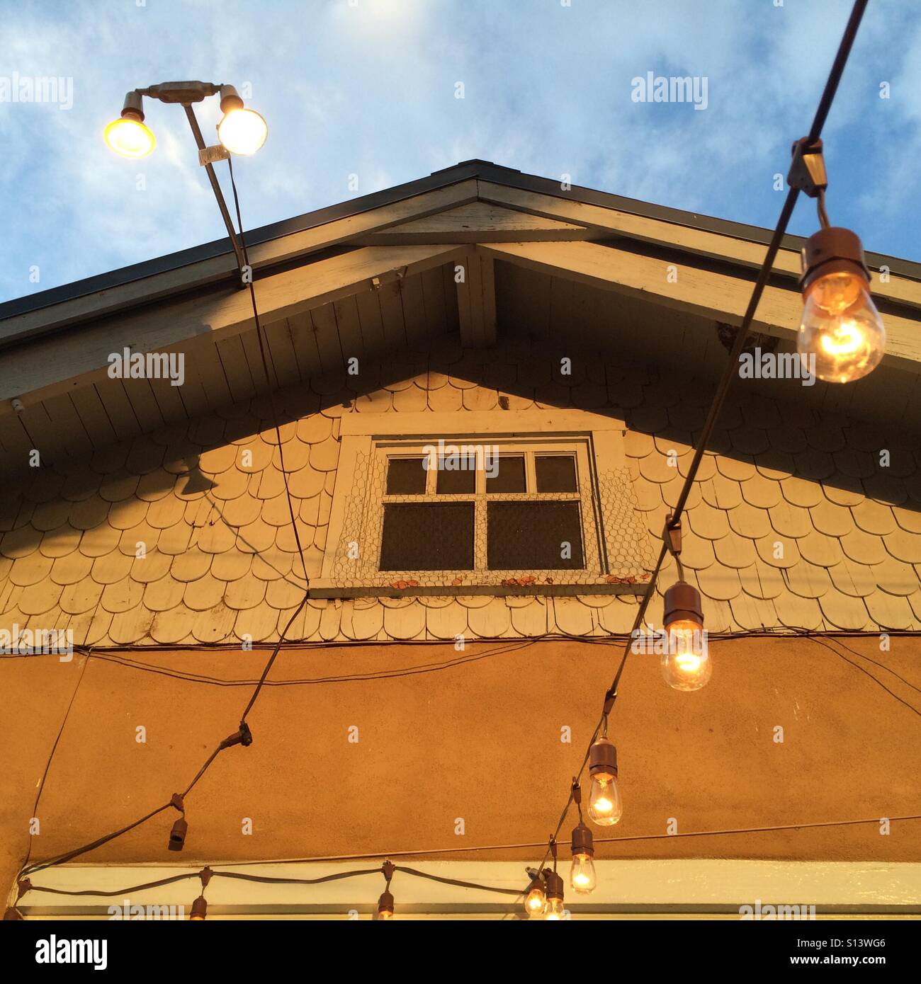 Evening decorative lights stand in front of an old building. Stock Photo