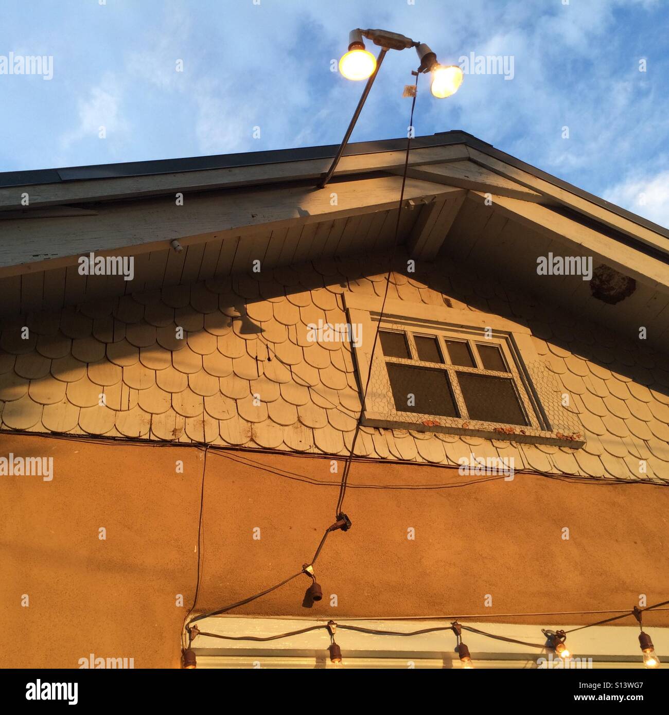Decorative lights hang over an old house. Stock Photo