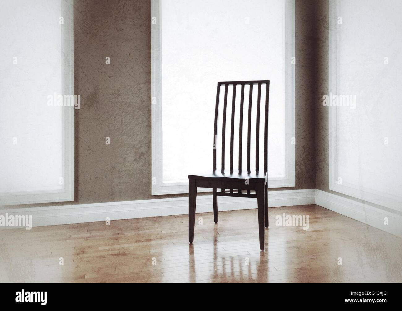A single high-back chair on a wooden floor surrounded by windows. - Smartphone Captured Stock Image