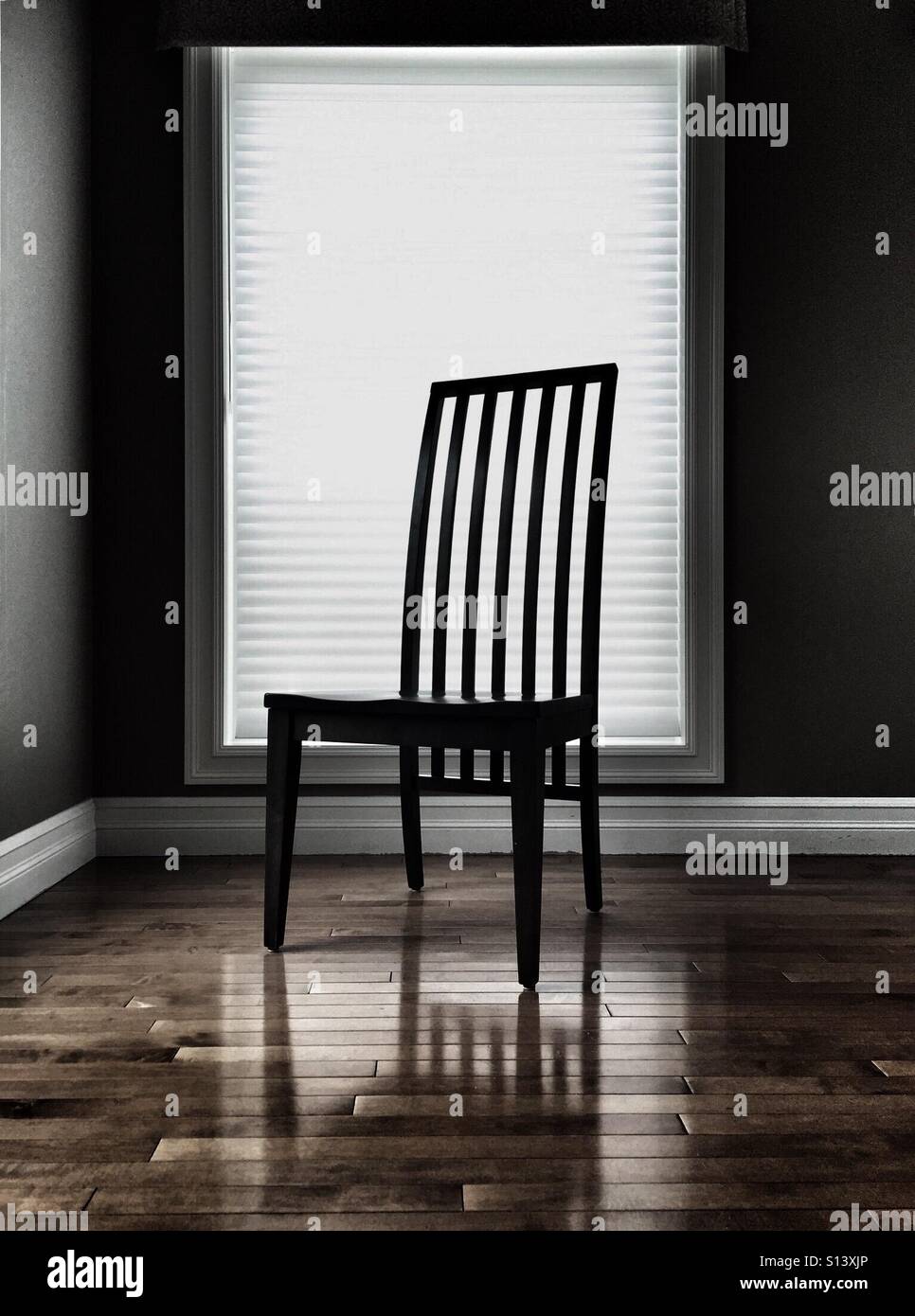 One chair stands in a room in front of a window. - Smartphone Captured Stock Image