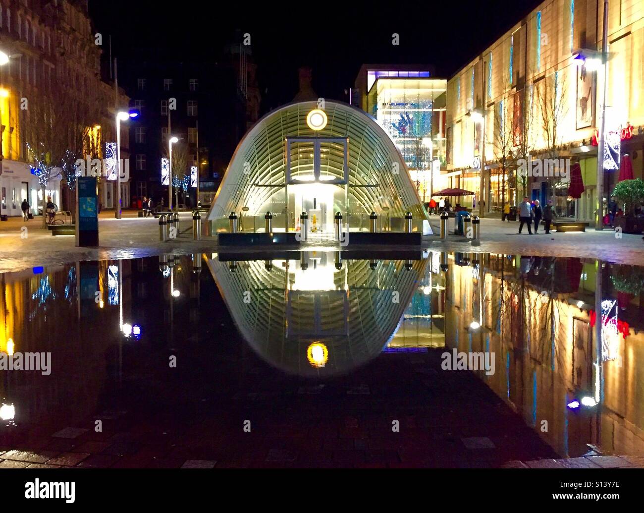 St Enoch Underground station, Glasgow, Scotland reflected in a pool of water at night. Stock Photo