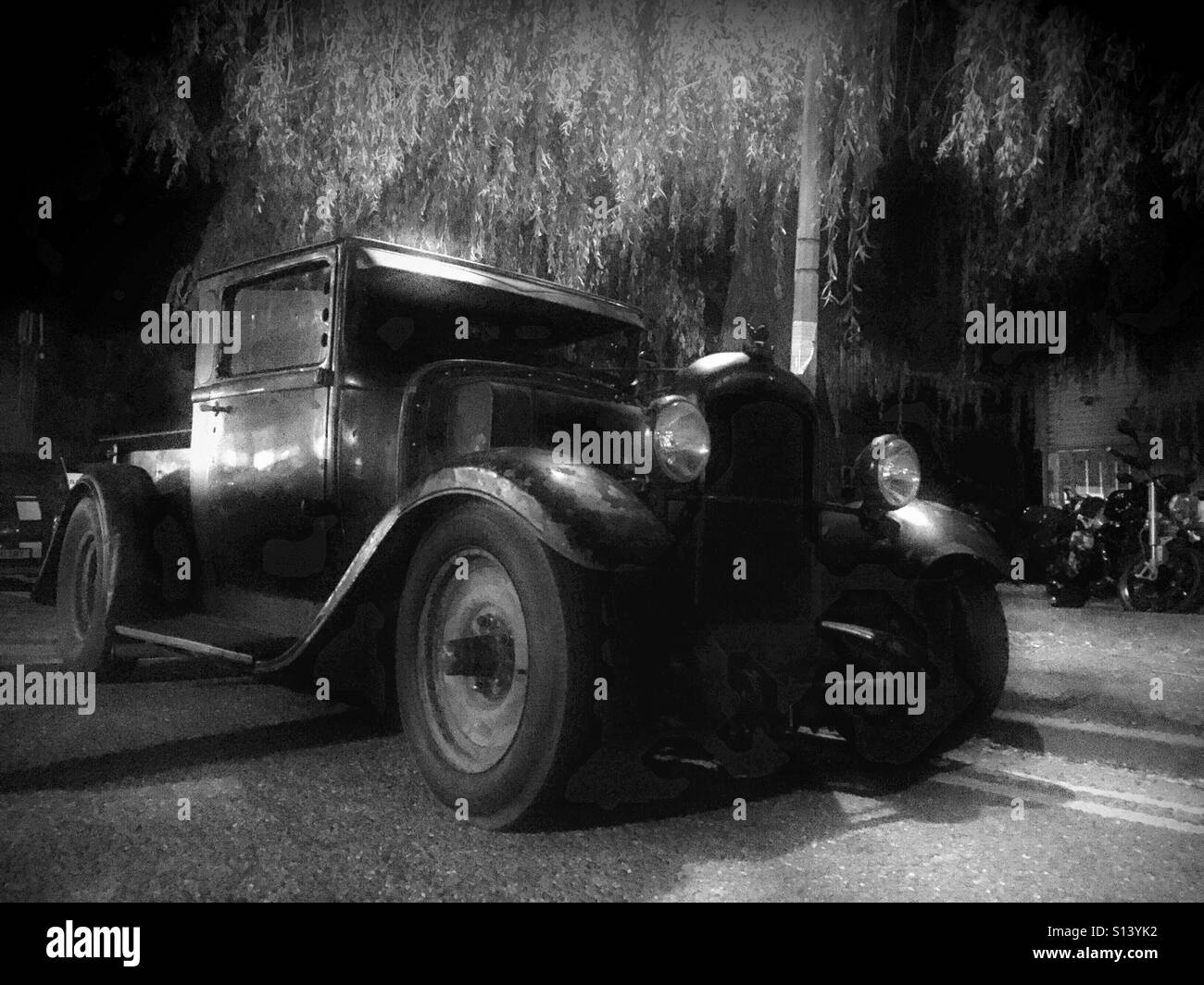 A classic American pick up truck under a tree at night. Stock Photo