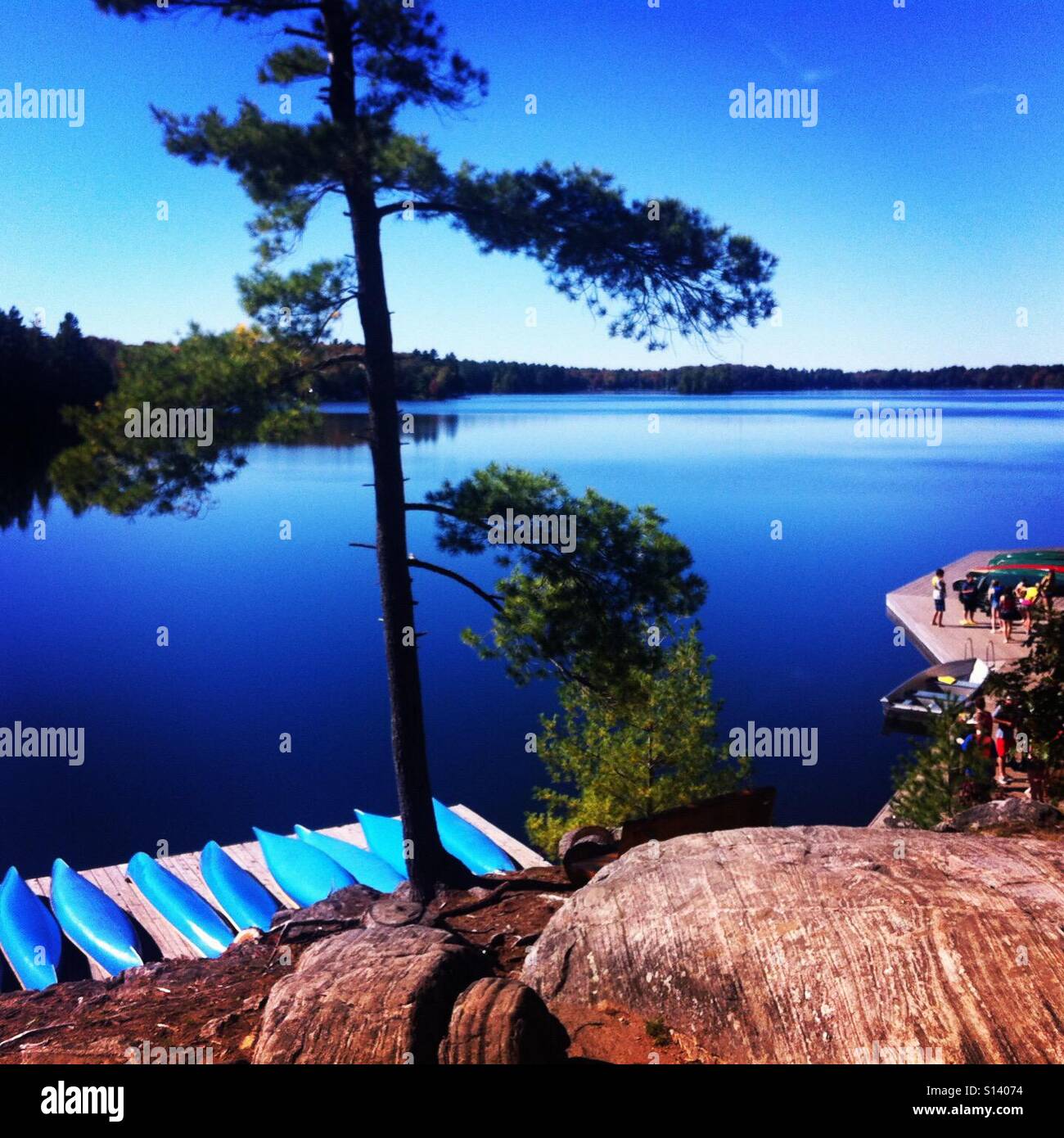 Summer lake with blue canoes Stock Photo