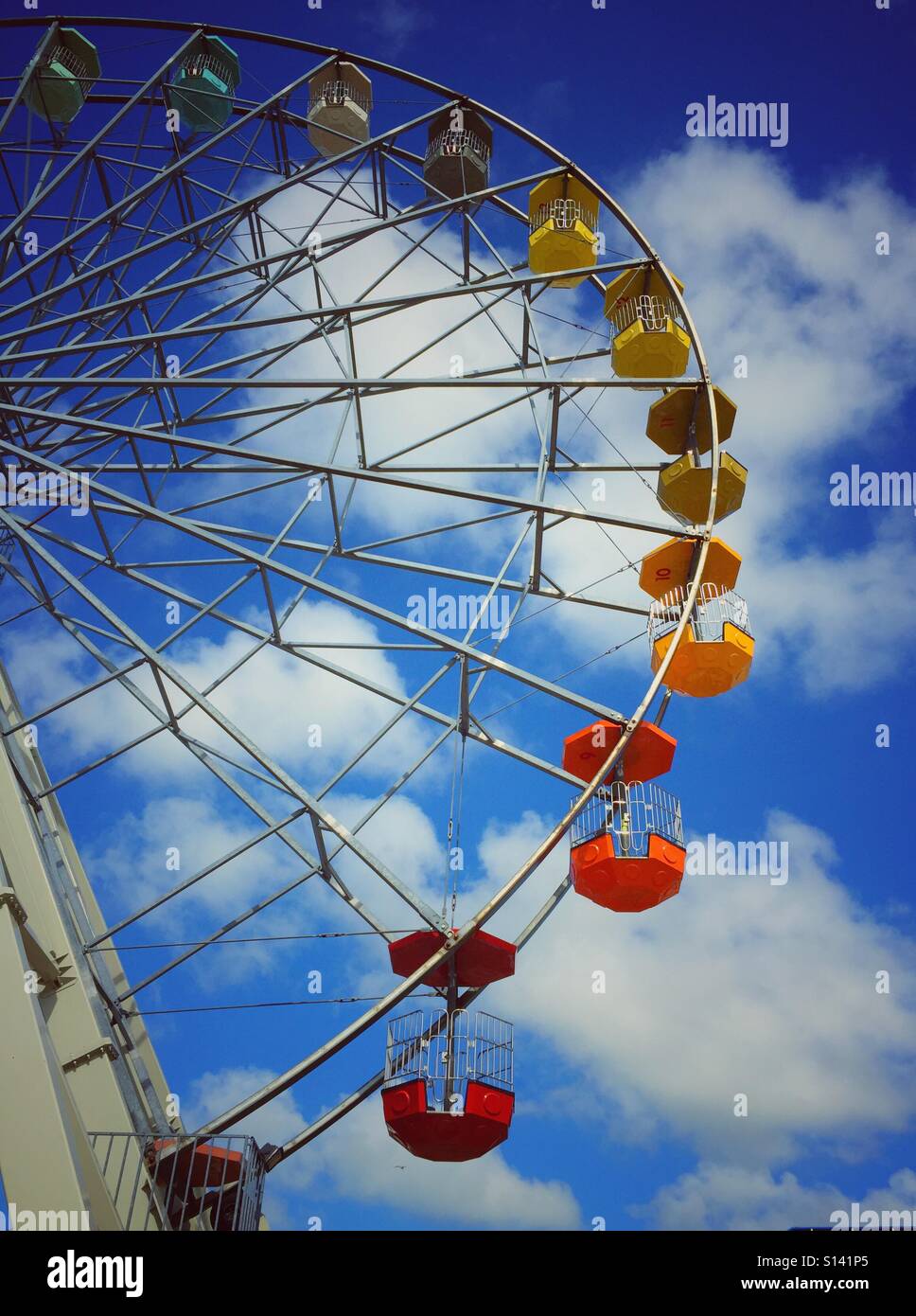 Brightly coloured passenger cars on a giant Ferris wheel - Smartphone Captured Stock Image