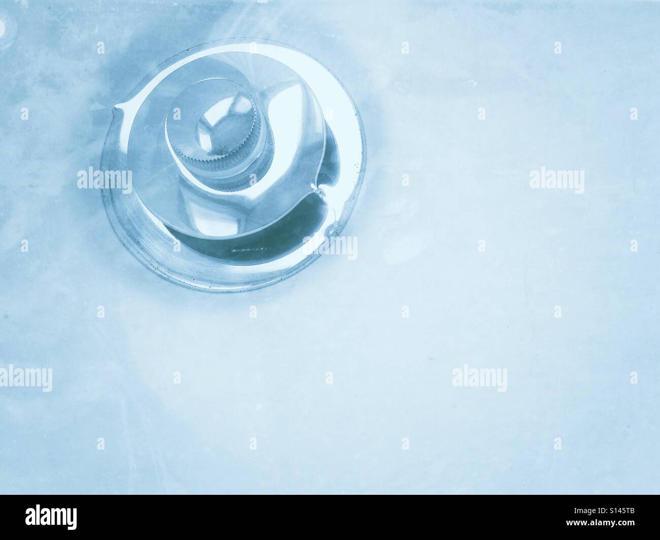 Water appears icy cold as it swirls down the drain. - Smartphone Captured Stock Image
