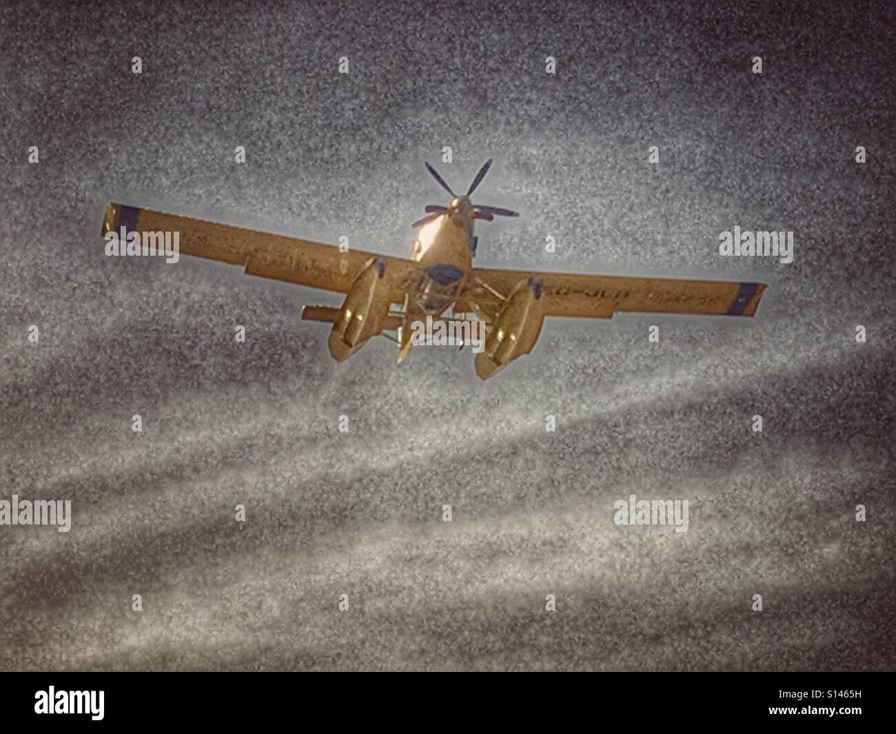 Amphibious aircraft flying through smoke filled sky to fight wildfire. - Smartphone Captured Stock Image