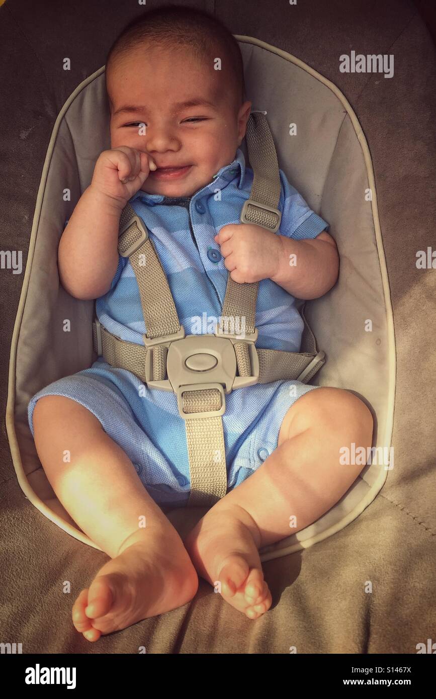1 month baby smiling in swing - Smartphone Captured Stock Image