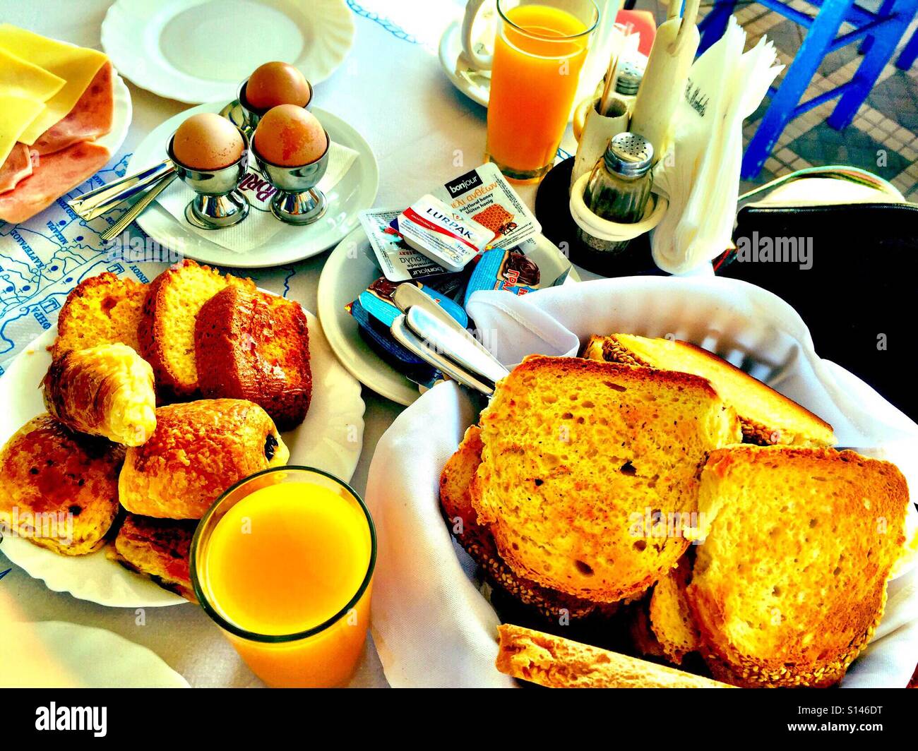 A hotel breakfast with eggs, toast, pastries and fresh orange juice. - Smartphone Captured Stock Image
