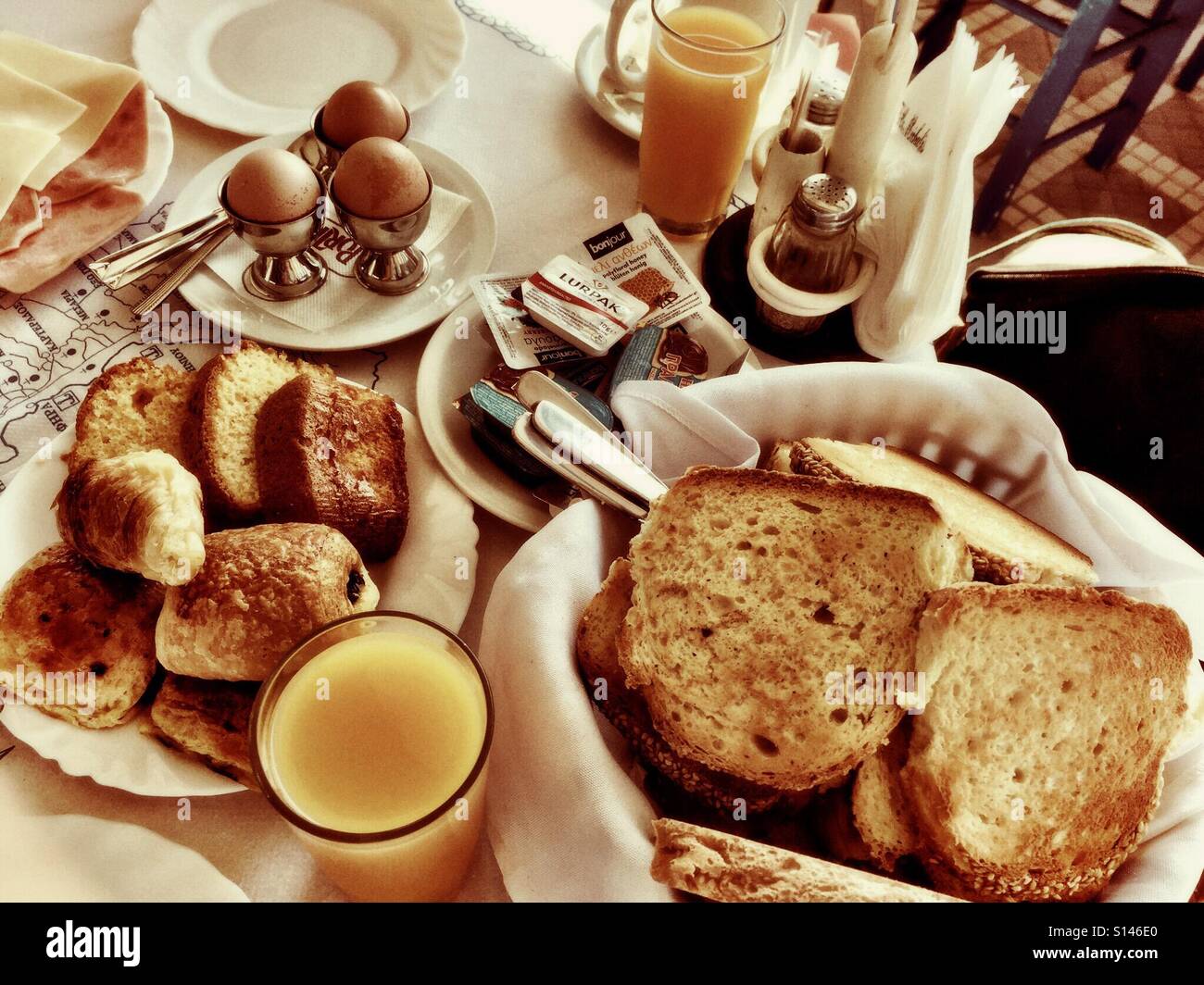 A hotel breakfast with eggs, toast, pastries and fresh orange juice. - Smartphone Captured Stock Image