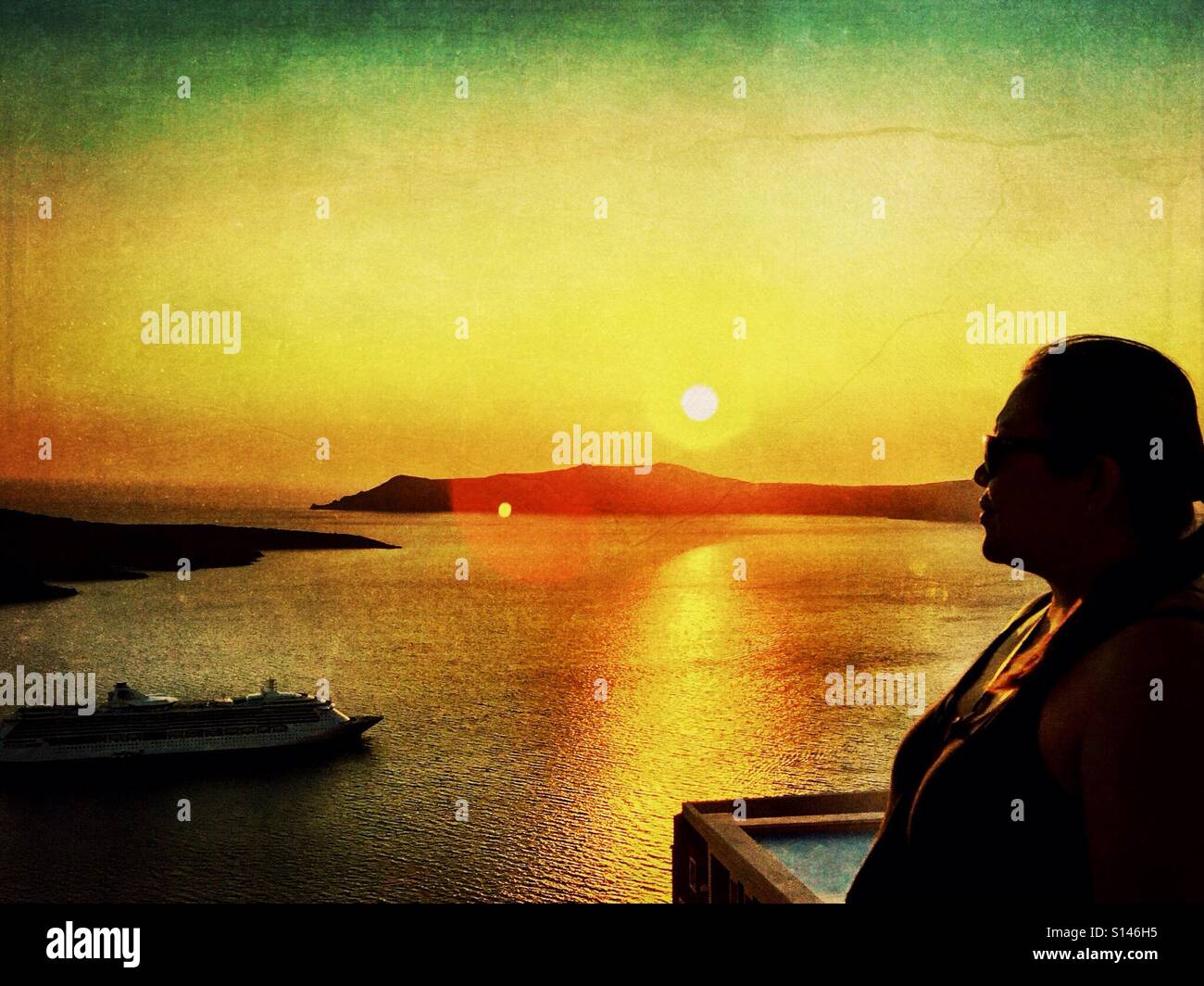 A lady in silhouette against a sunset on the Greek island of Santorini. - Smartphone Captured Stock Image