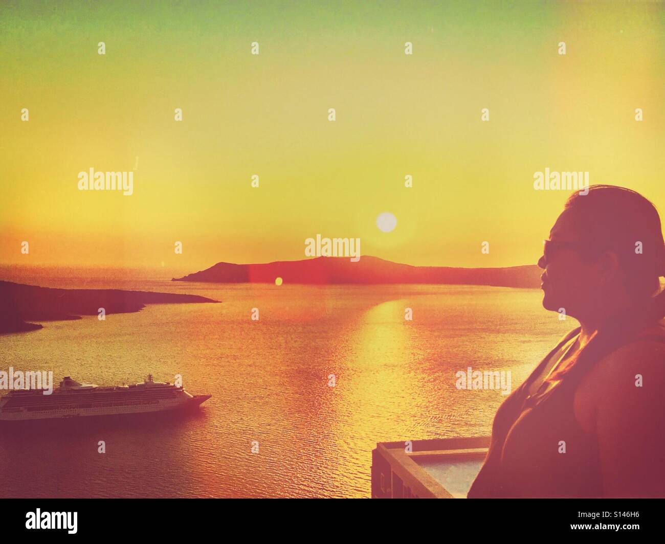 A lady in silhouette against a sunset on the Greek island of Santorini. - Smartphone Captured Stock Image