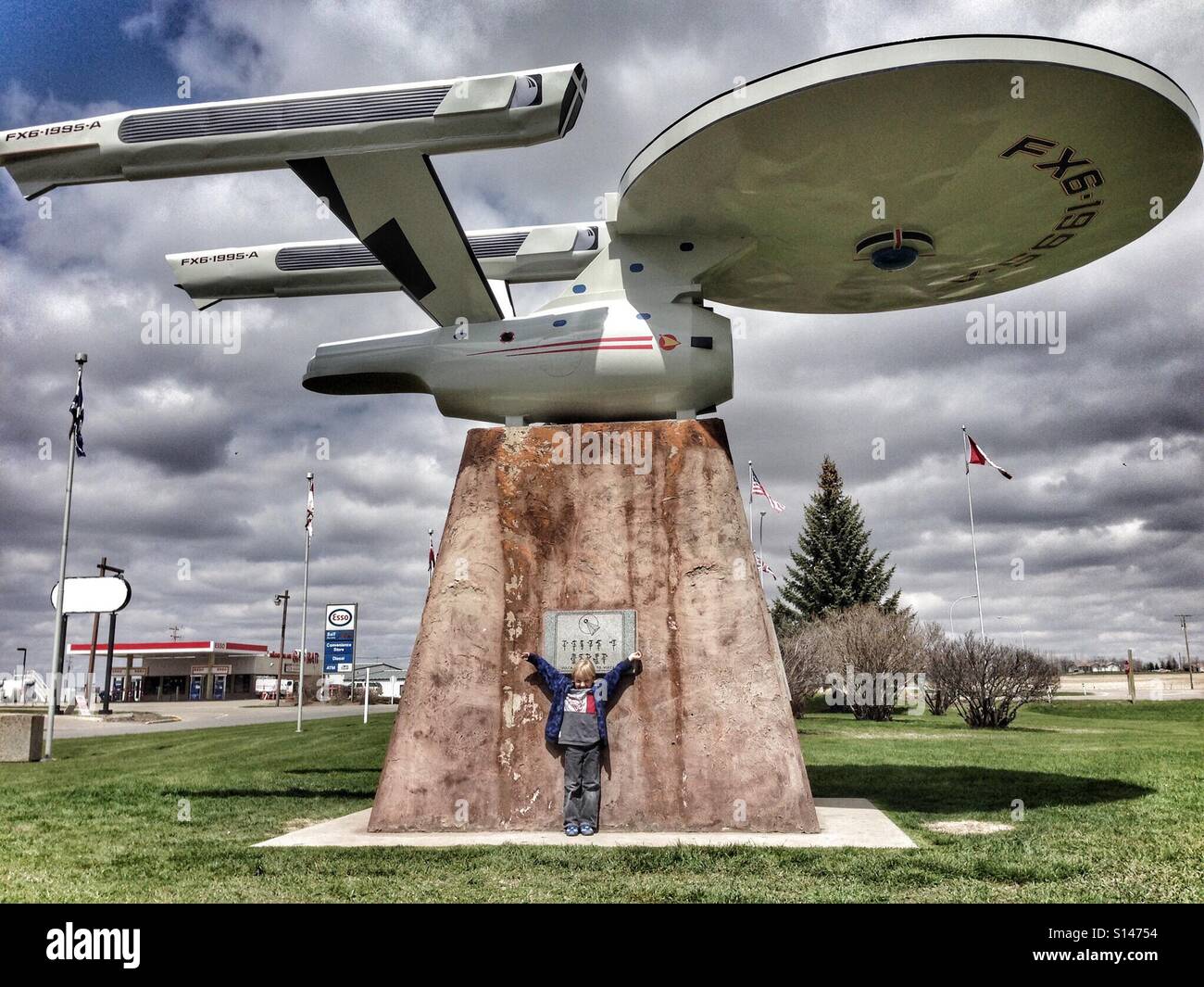 A boy is thrilled to be photographed with a model of Star Trek's starship Enterprise in Vulcan, Alberta, Canada. - Smartphone Captured Stock Image