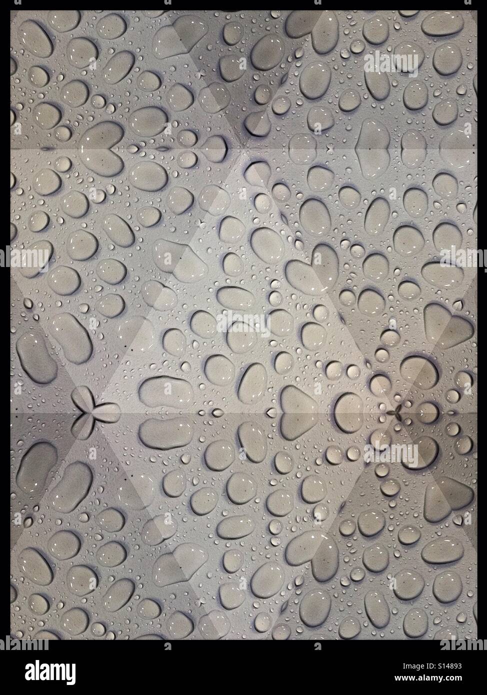 Mozaic effect applied to raindrops on a white table Stock Photo