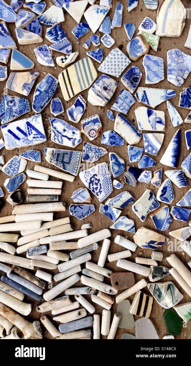 Mudlarking finds of clay pipes and pottery fragments from the sides of the river Thames, in Wapping, London. Stock Photo