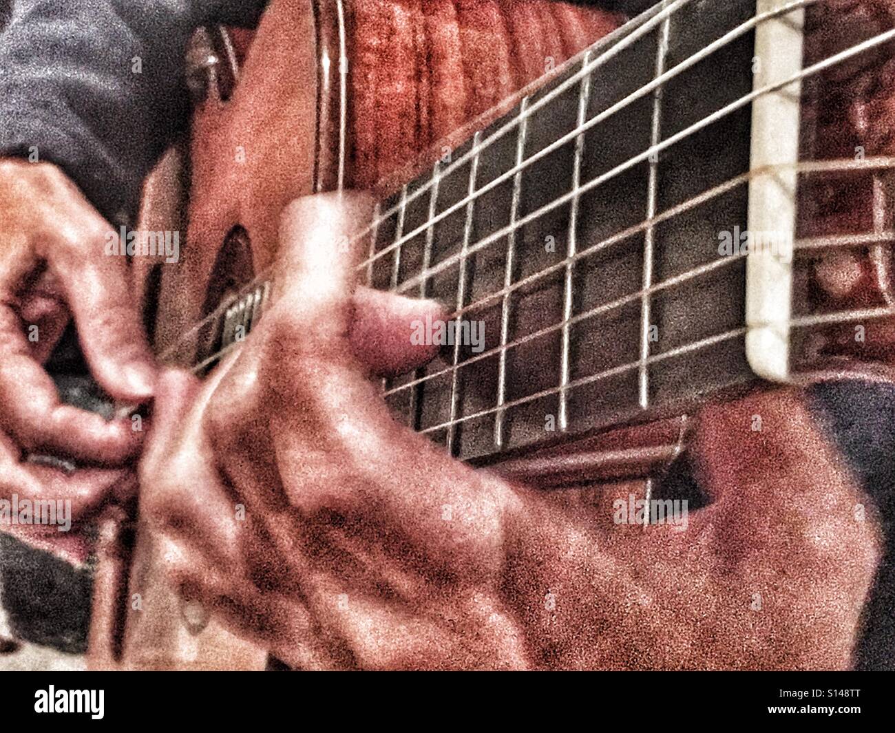 Woman playing guitar, close up of hands and fret board - Smartphone Captured Stock Image