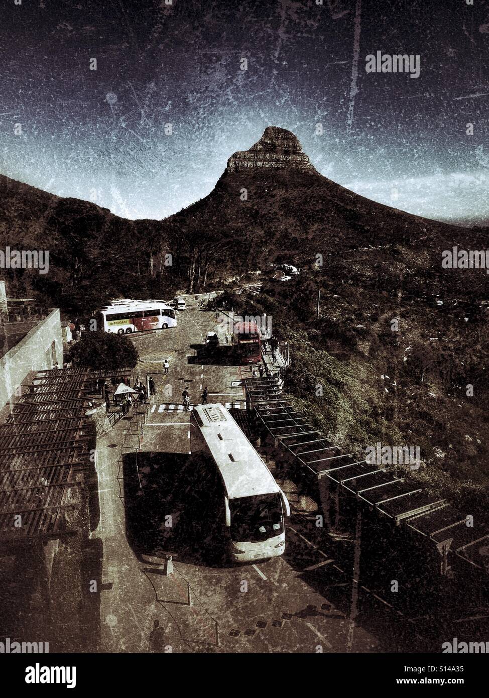 Tour bus at Table Mountain cable car station with Lions Head in the background Stock Photo