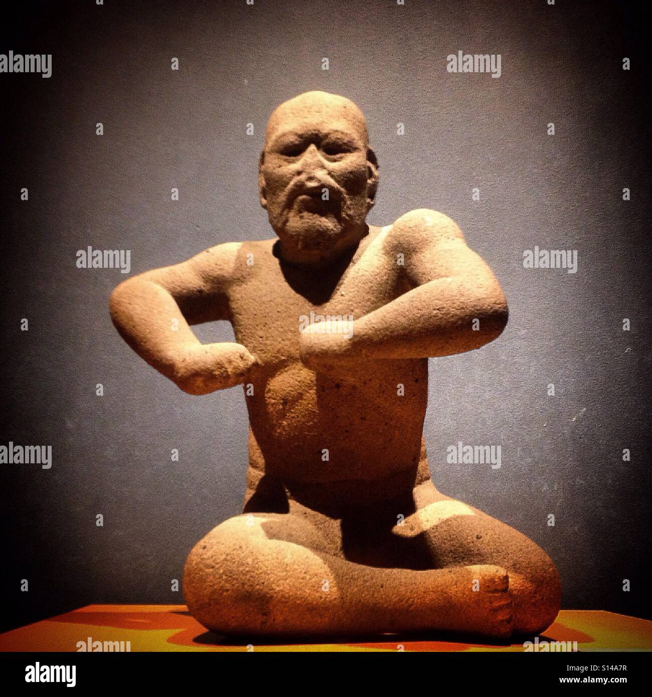 The Olmec sculpture of an old man decorates the Museo Nacional de Antropologia in Mexico City, Mexico - Smartphone Captured Stock Image